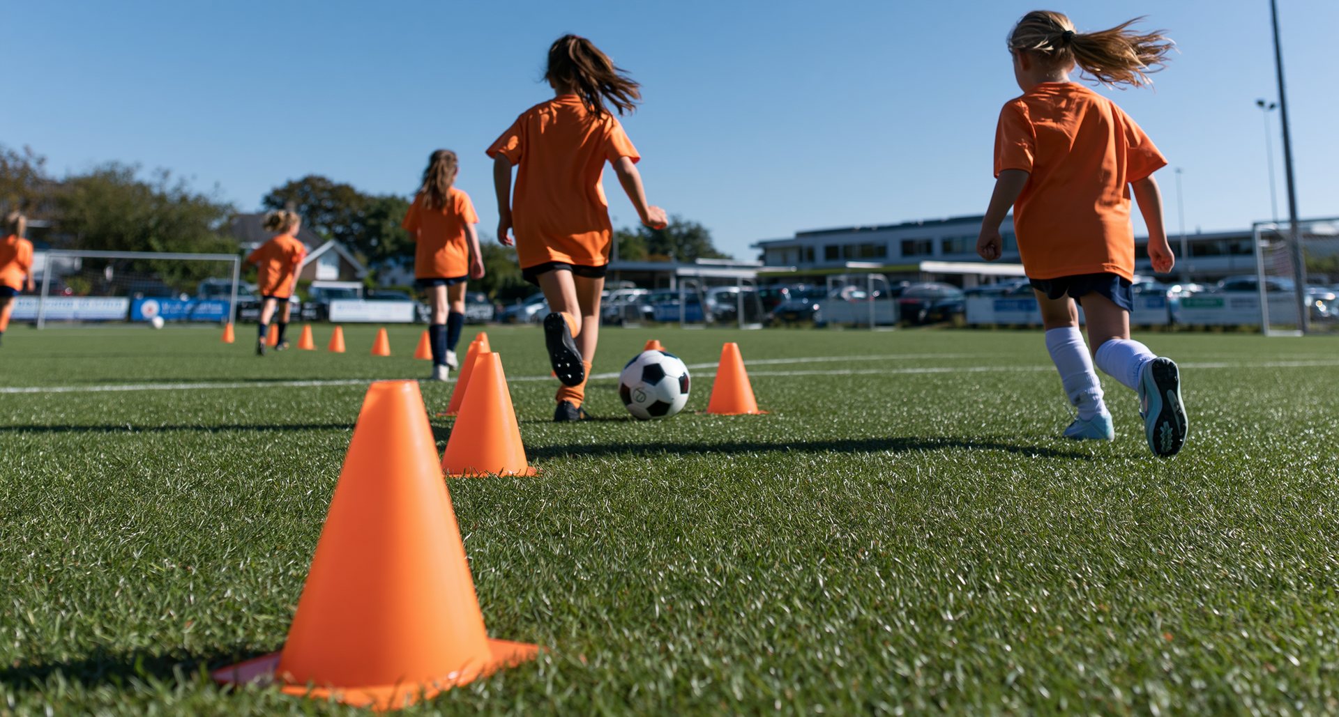 Jeugdspelers van achteren gezien tijdens de training op een bewolkte ochtend